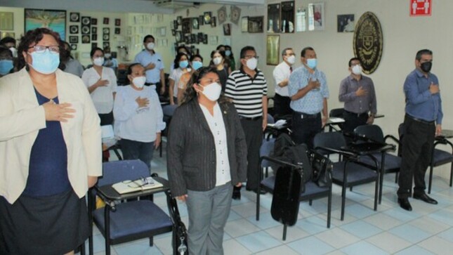 Autoridades y docentes cantando el Himno Nacional