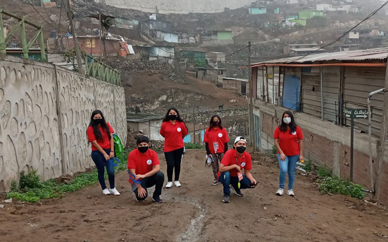 Jóvenes con polo rojos que realizan un voluntariado