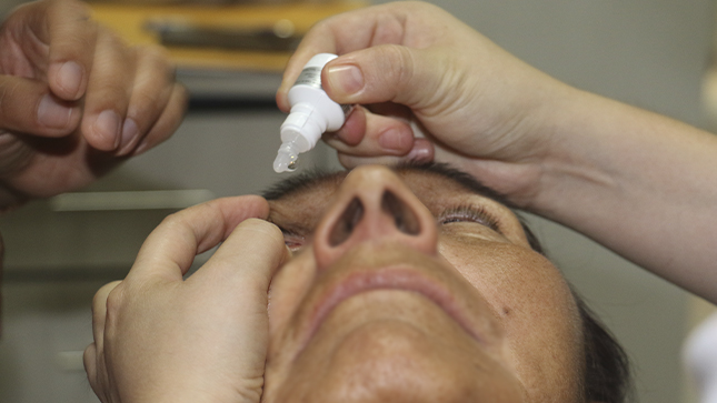 Una persona se hecha gotas de un medicamento al ojo.