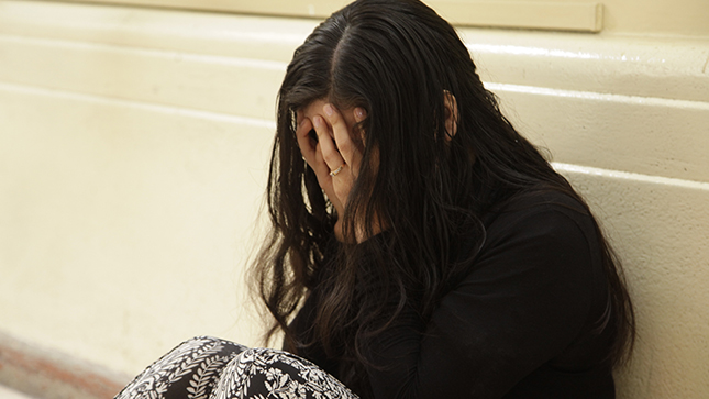 Una adolescente que esta deprimida mira al suelo