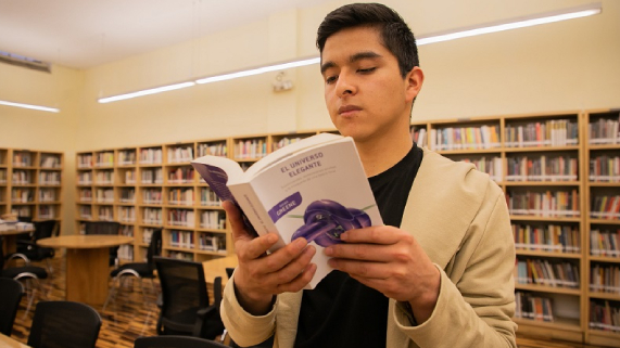 Héctor leyendo el libro que más impactó su vida, El Universo elegante
