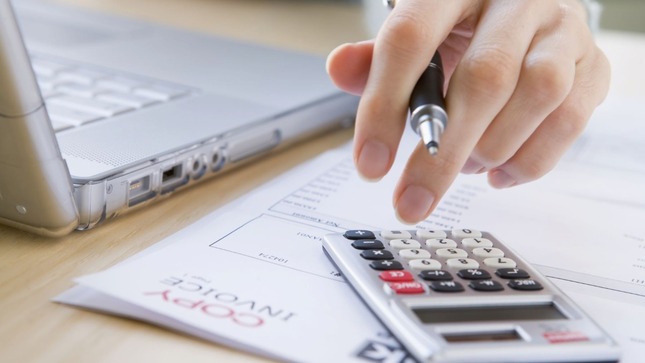 Imagen de mano operando una calculadora