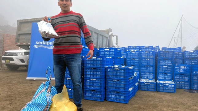 Señor recibe bolsa con agua repartida por Sedapal. 