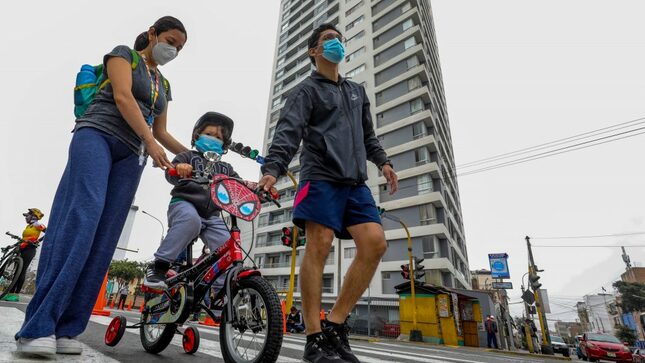 Una pareja pasea a su menor hijo en bicileta por la avenida Brasil.