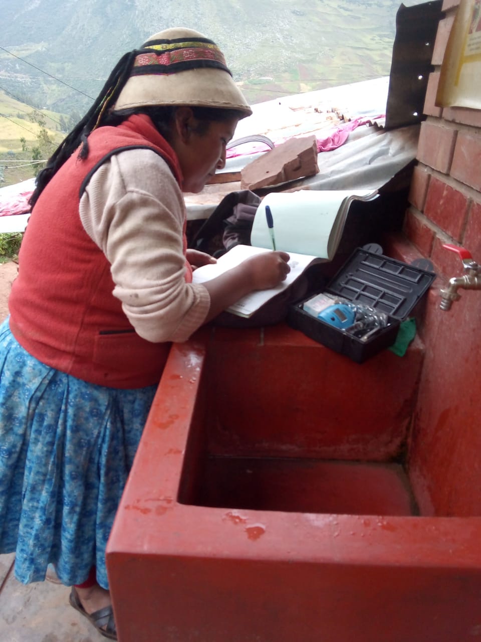 Mujer miembro del JASS haciendo la medición del cloro residual