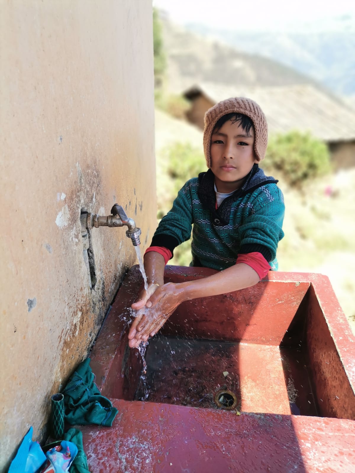 Niño lavandose las manos con agua potable