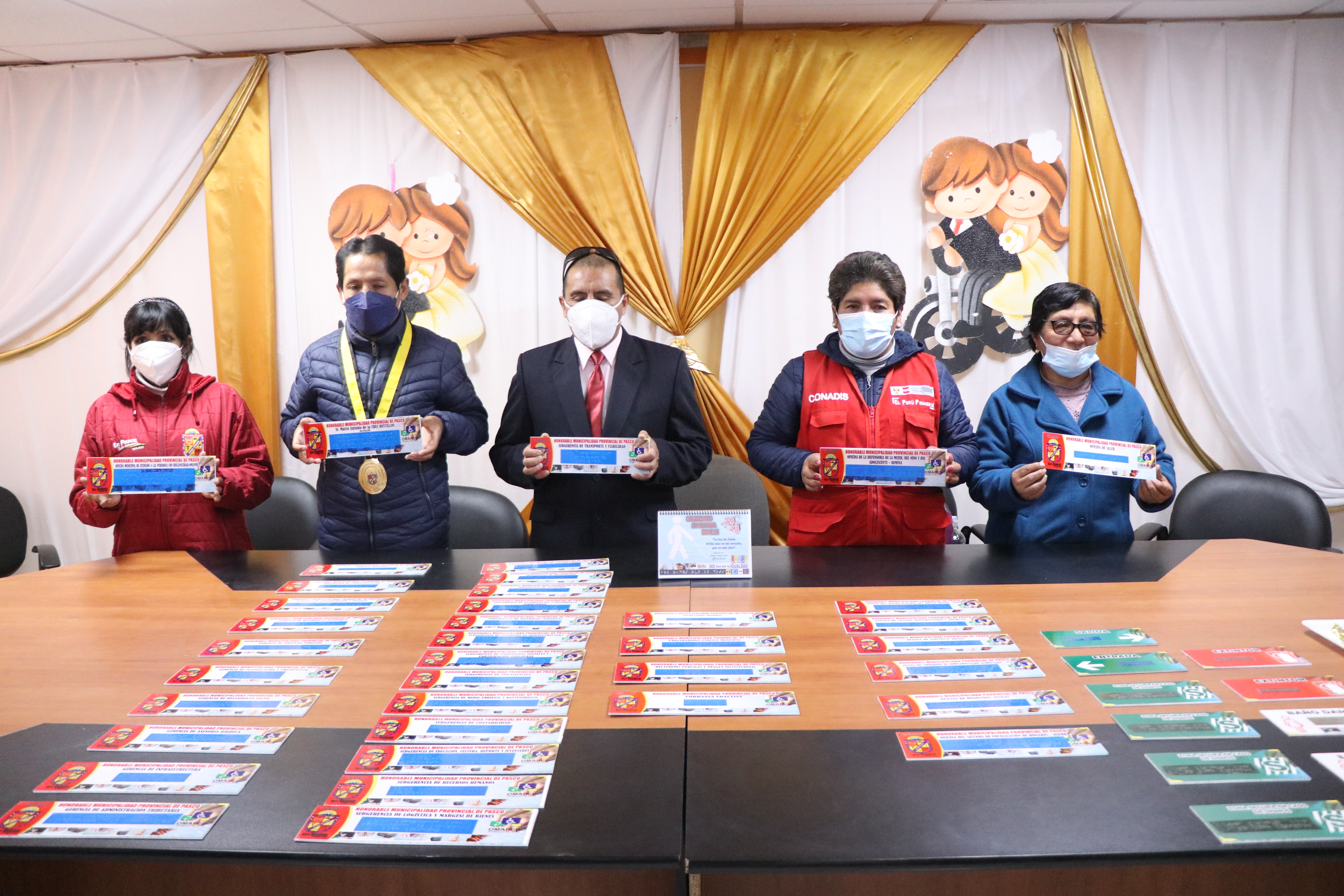 Fotografía general de las autoridades presentando los rótulos en sistema de escritura braille que serán colocados en todas las oficinas de la institución municipal.