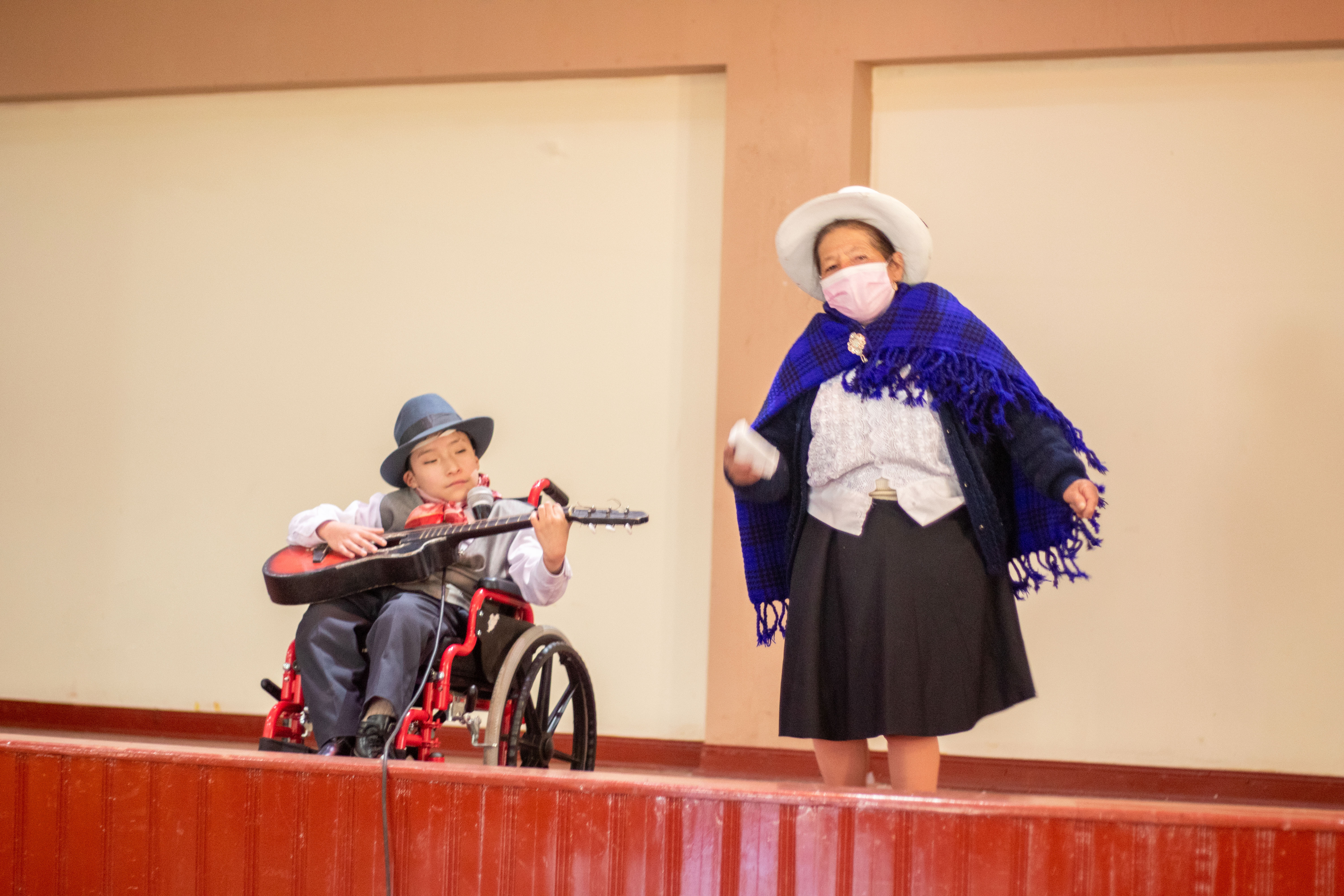 Participación del concurso de niño en silla de ruedas acompañado de una persona vestida de cerreña.