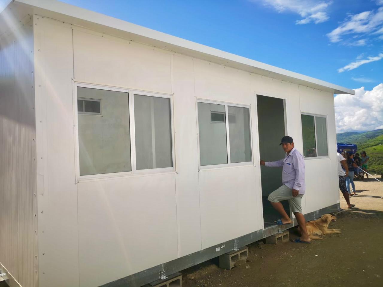 Foto de módulo temporal de vivienda y beneficiario.