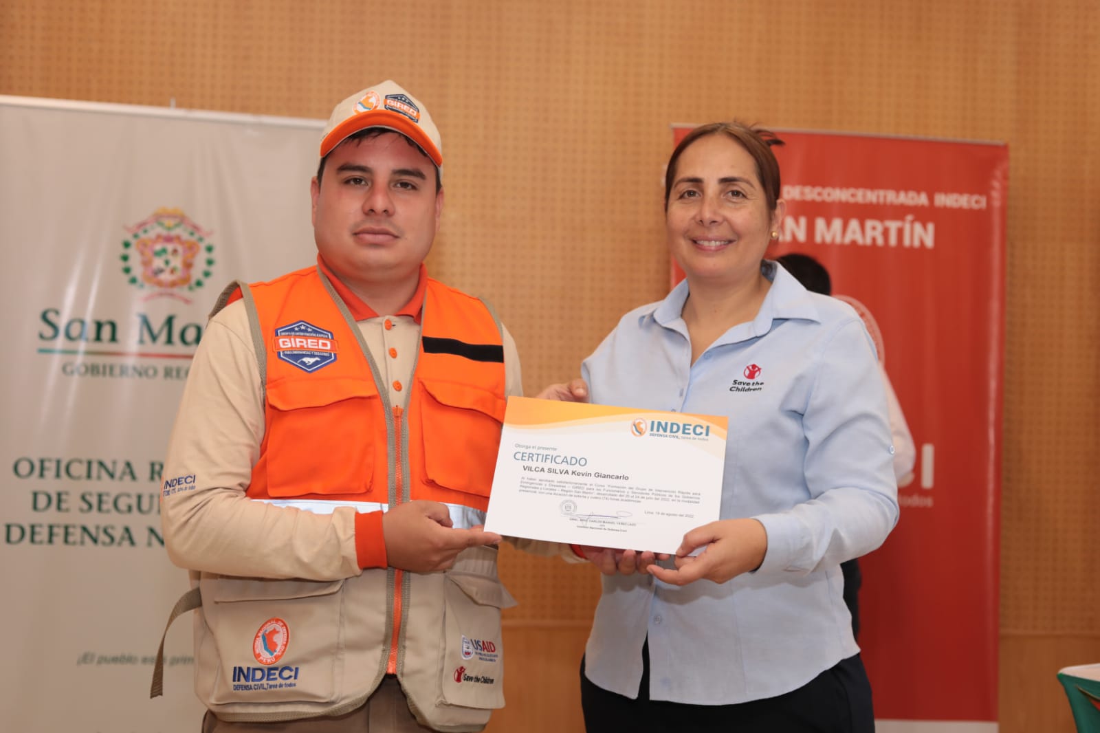 Participante del curso recibe certificado por parte de la representante de “Save The Children International".