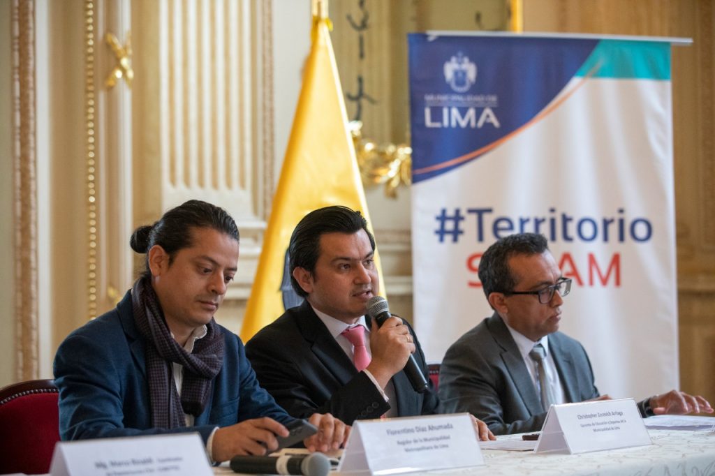 Funcionarios de la Municipalidad de Lima dialogando durante evento.