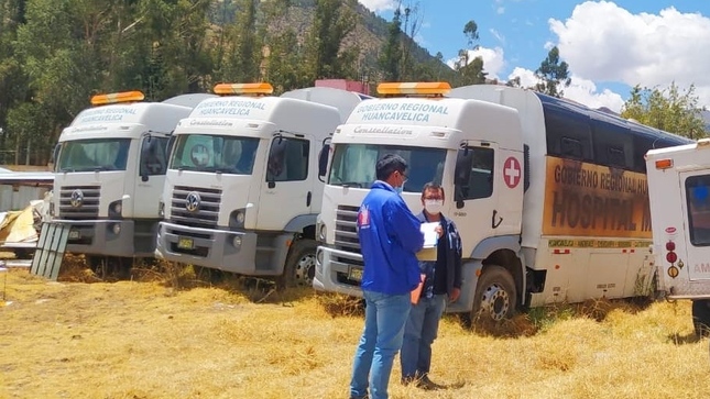 Foto de comisionado de la Defensoría con representante de centro de salud observando ambulancias
