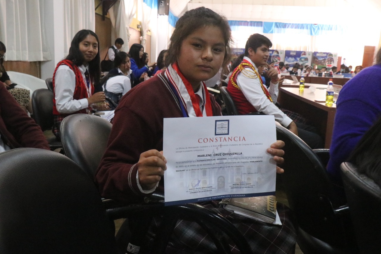 Escolar mostrando su constancia como Parlamentaria Escolar