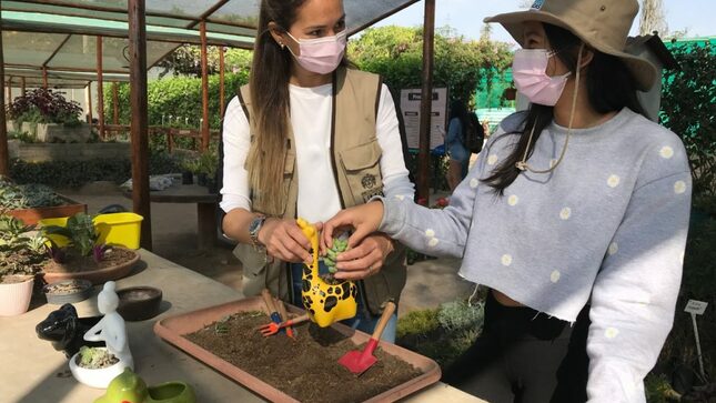 Dos mujeres realizando tareas de jardinería.