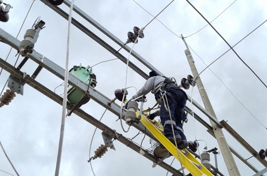 En la imagen está un técnico reparando los cables del sistema eléctrico