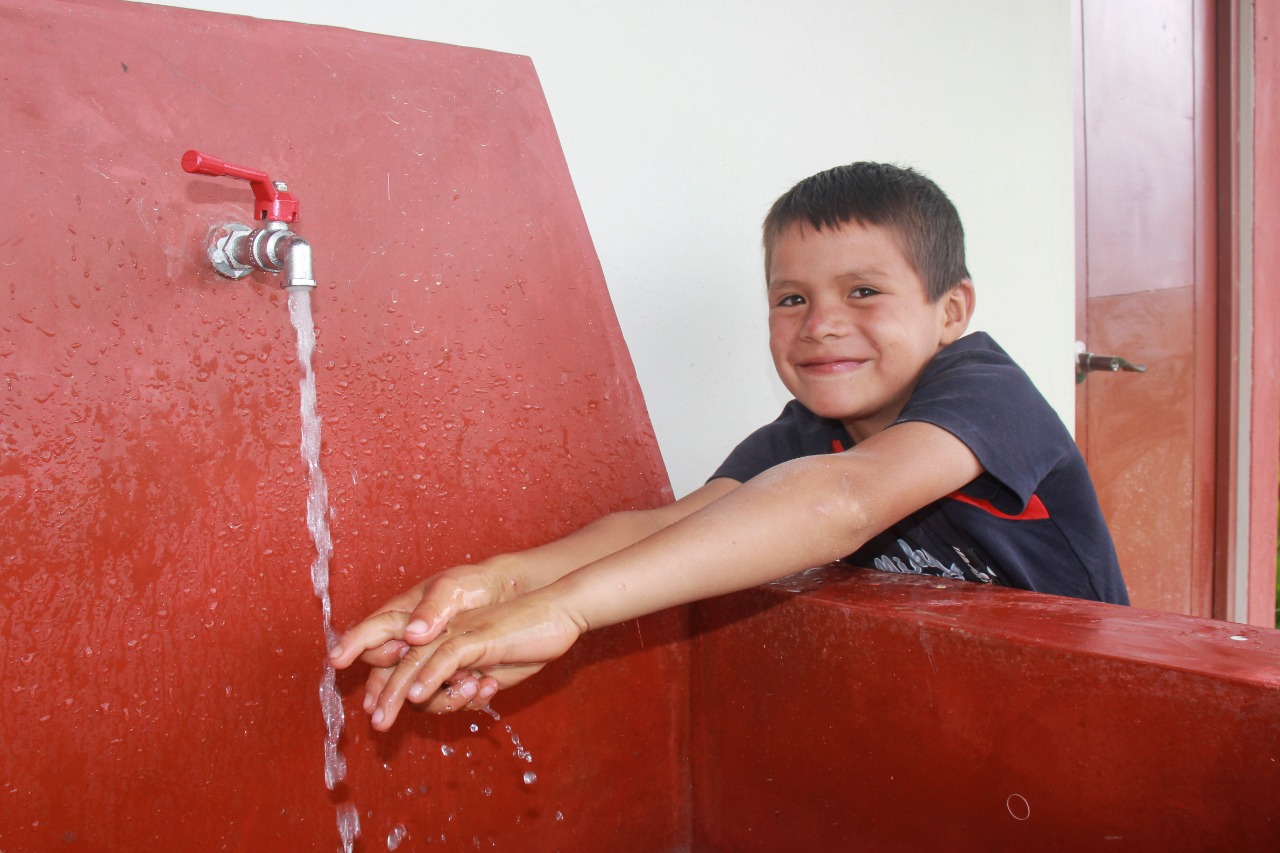 Niño de comunidad lavándose las manos en su lavadero de su UBS