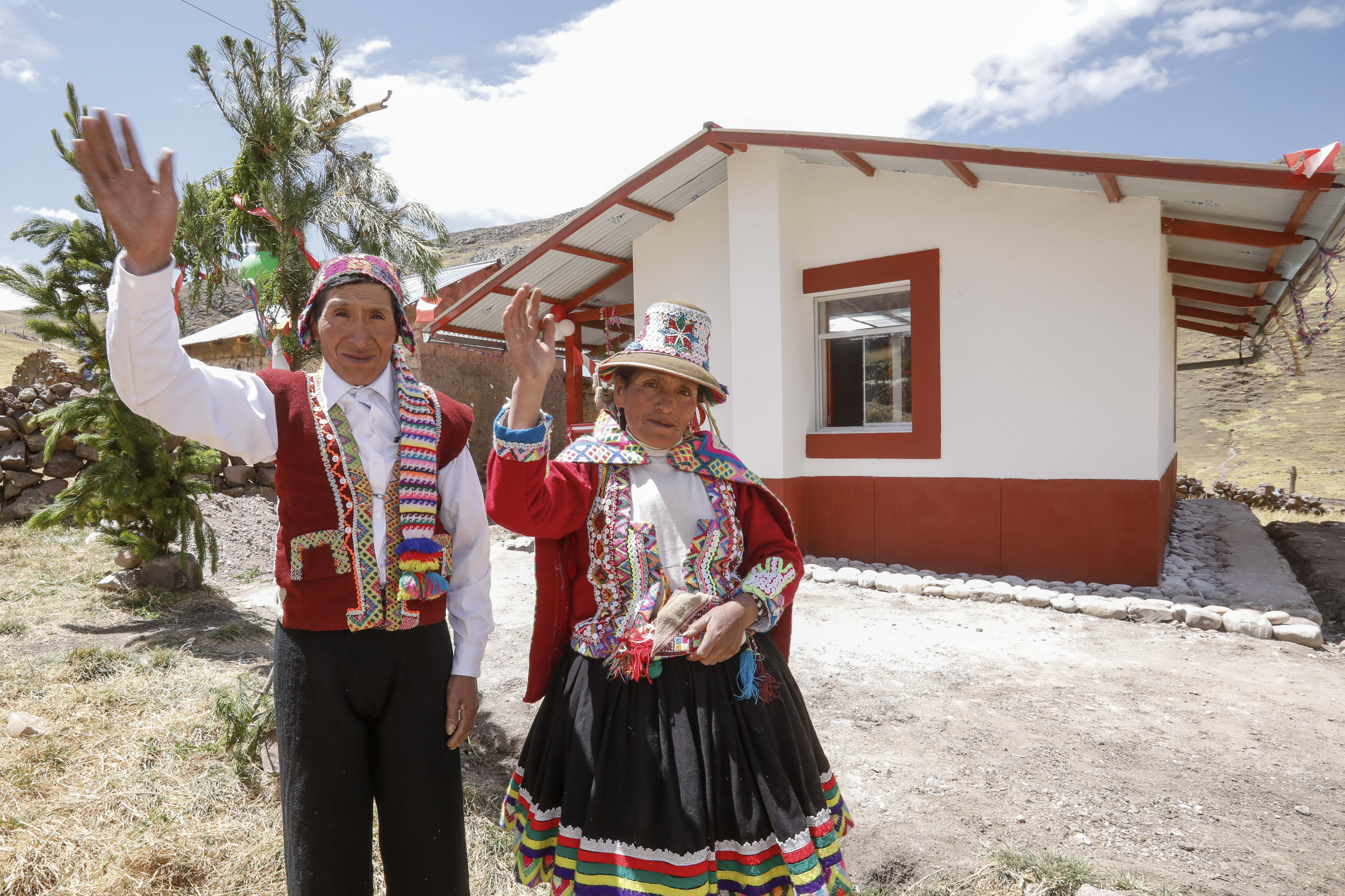 Pareja de beneficiarios posan delante de su nueva vivienda