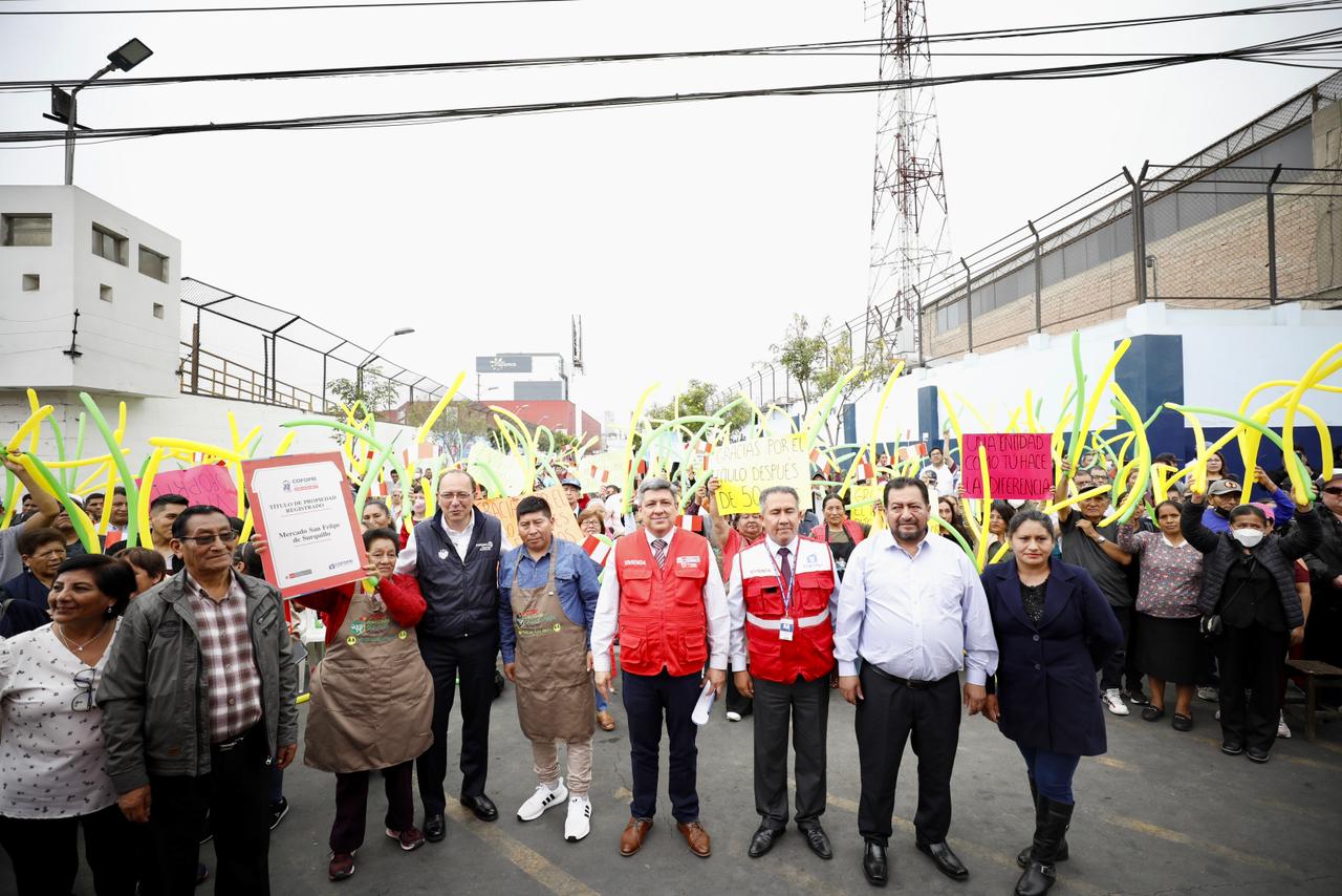 Comerciantes y autoridades posan con título de propiedad
