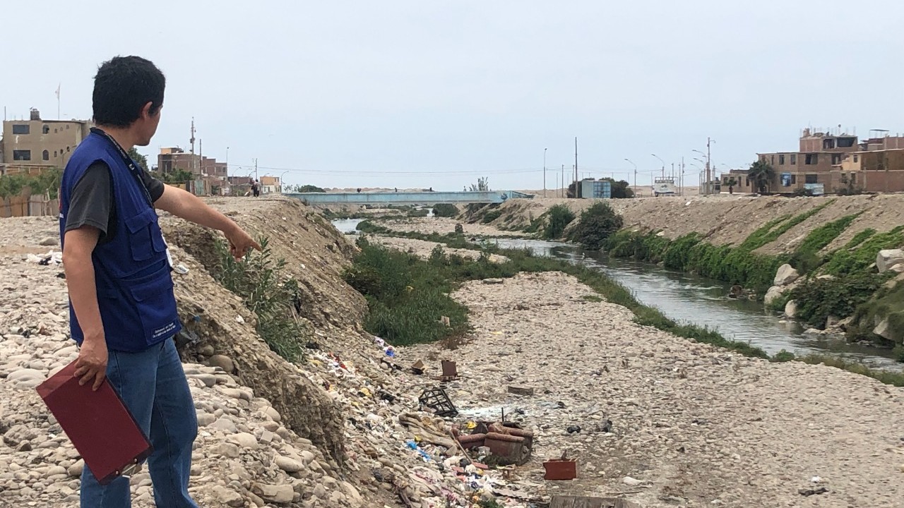 Fotografía de comisionado de la Defensoría del Pueblo supervisando rivera de río.