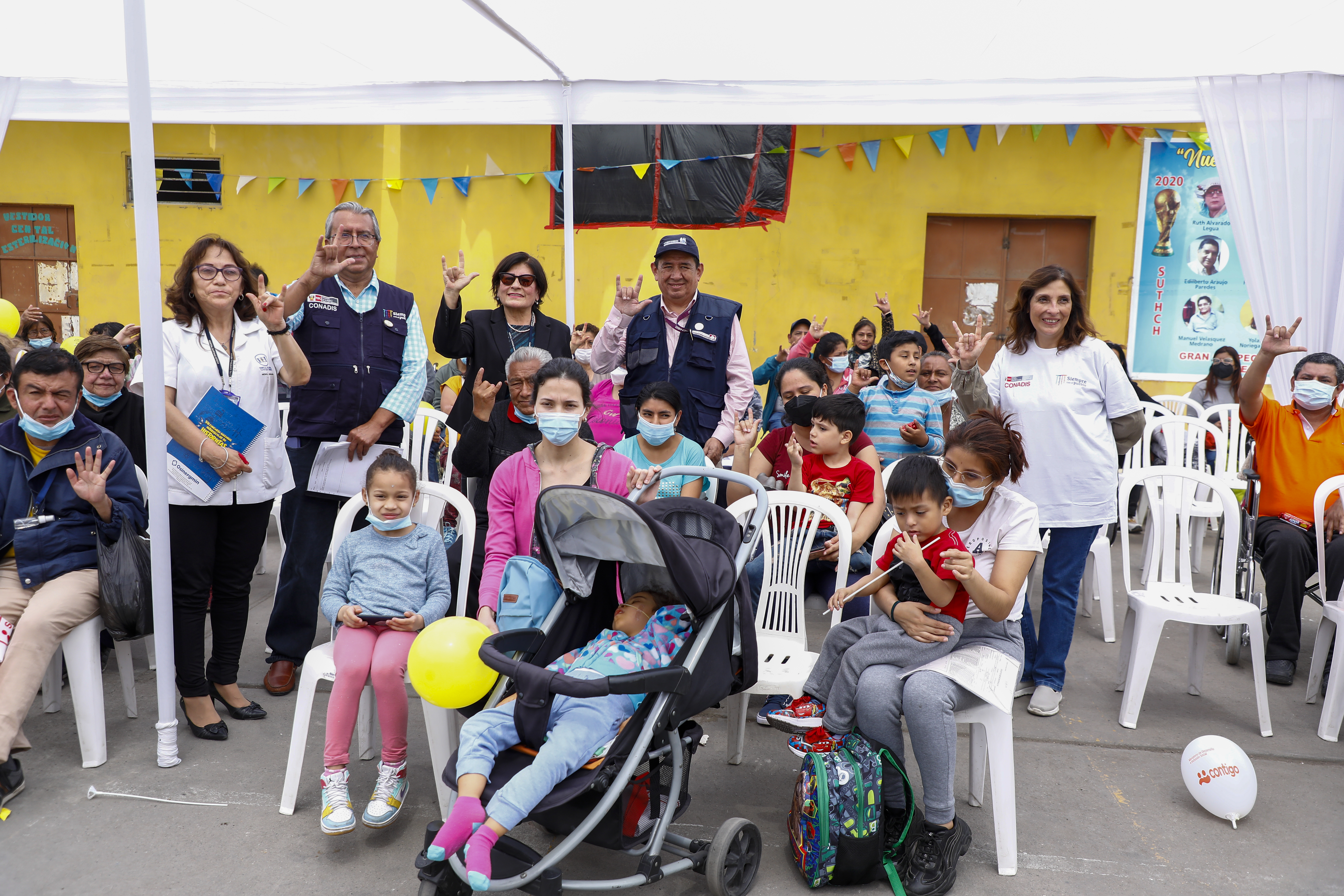 autoridades y personas con discapacidad saludando