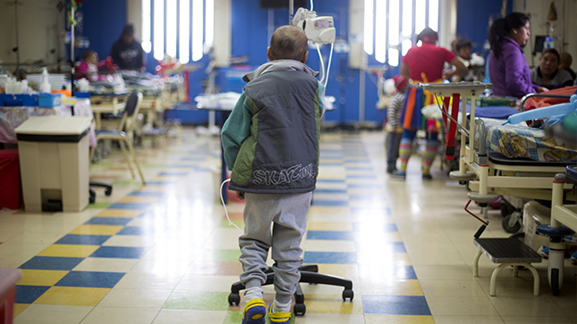  Se ve un niño con cáncer caminando de espalda.