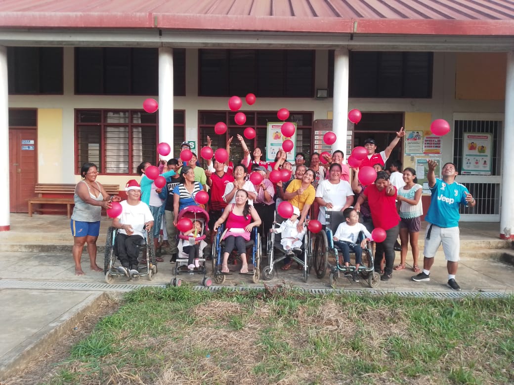 Usuarios y cuidadores del programa CONTIGO alegres con globos