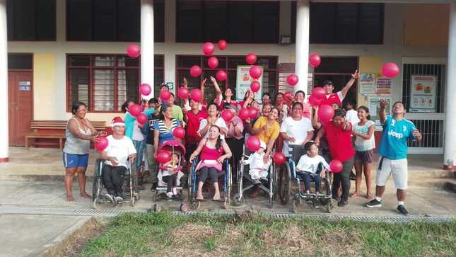 Usuarios y cuidadores del programa CONTIGO alegres con globos