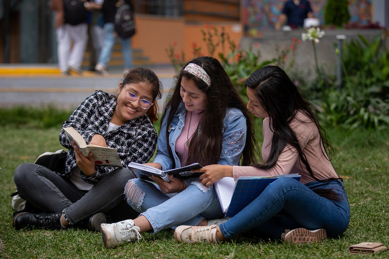 Jóvenes estudiantes revisando libros.