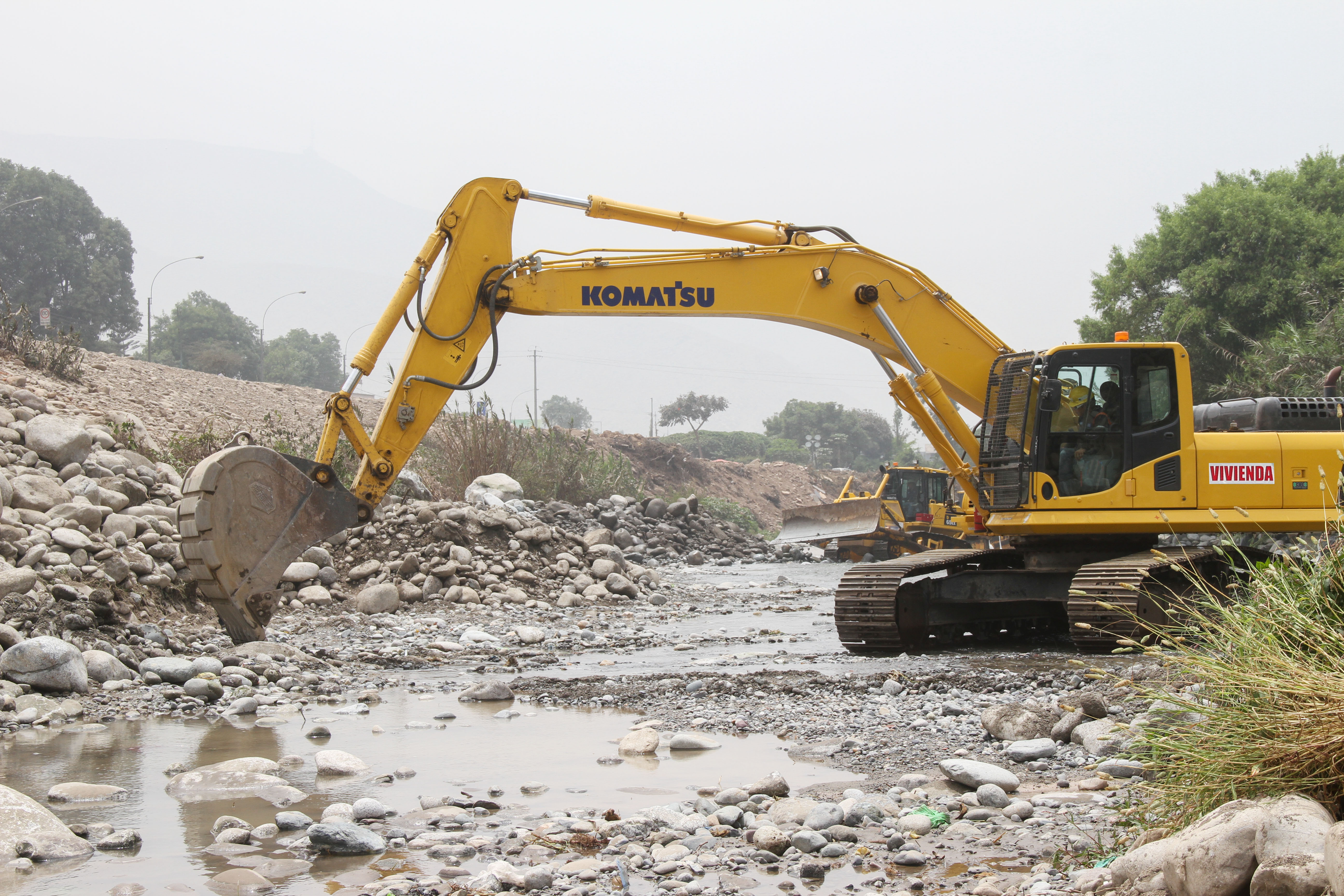 Foto de maquinaria realizando labores de descolmatación en un río.