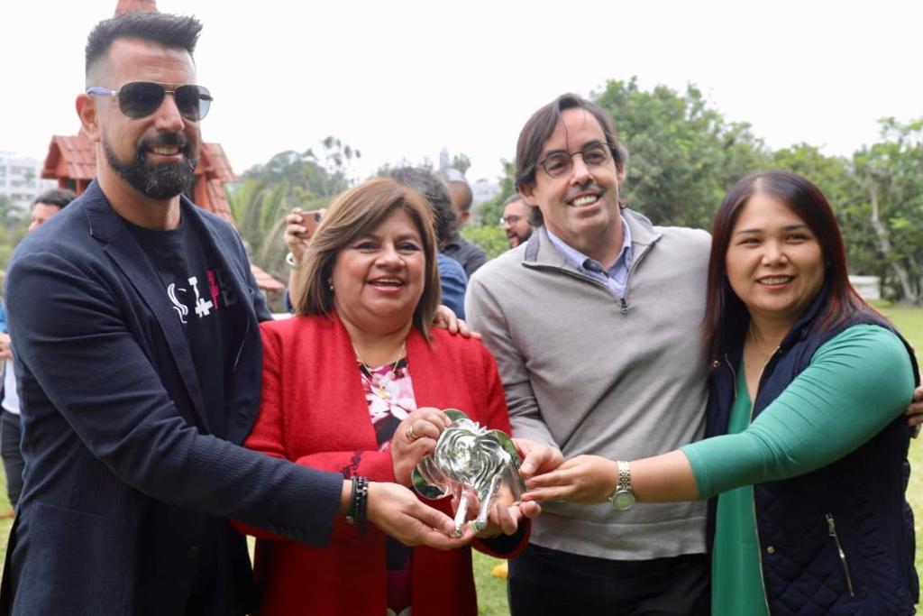 Se ve a la Ministra de Salud y representantes de Circus Grey mostrando el premio.