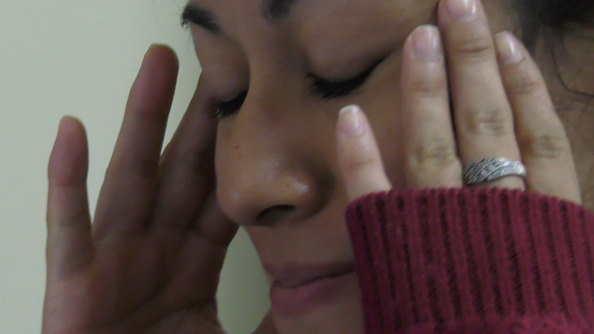 Una joven se agarra la cabeza de dolor.