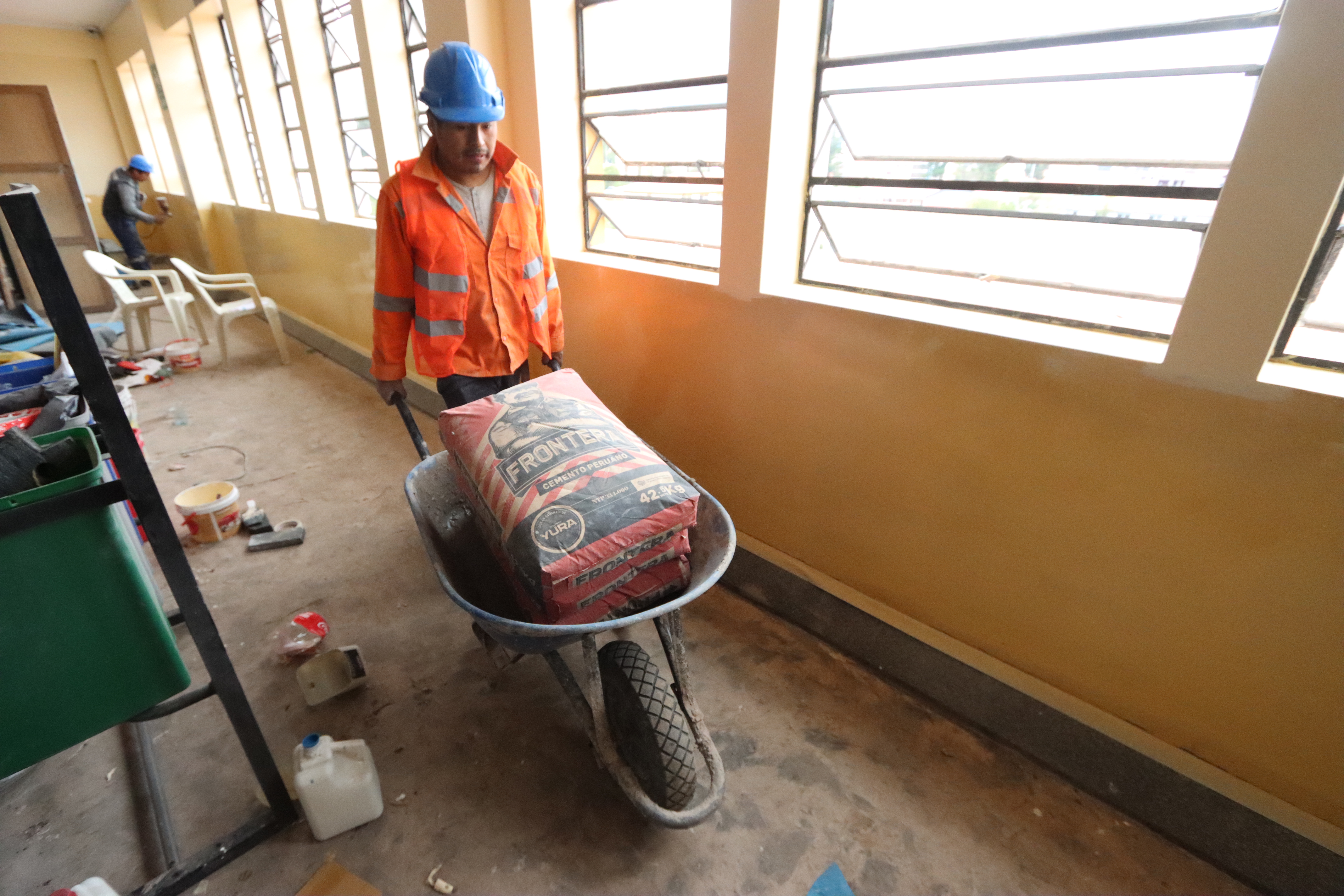 Traslado de cemento por un trabajador de la obra de mantenimiento