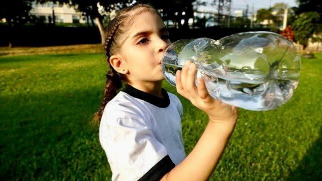 niña tomando agua del tomatodo