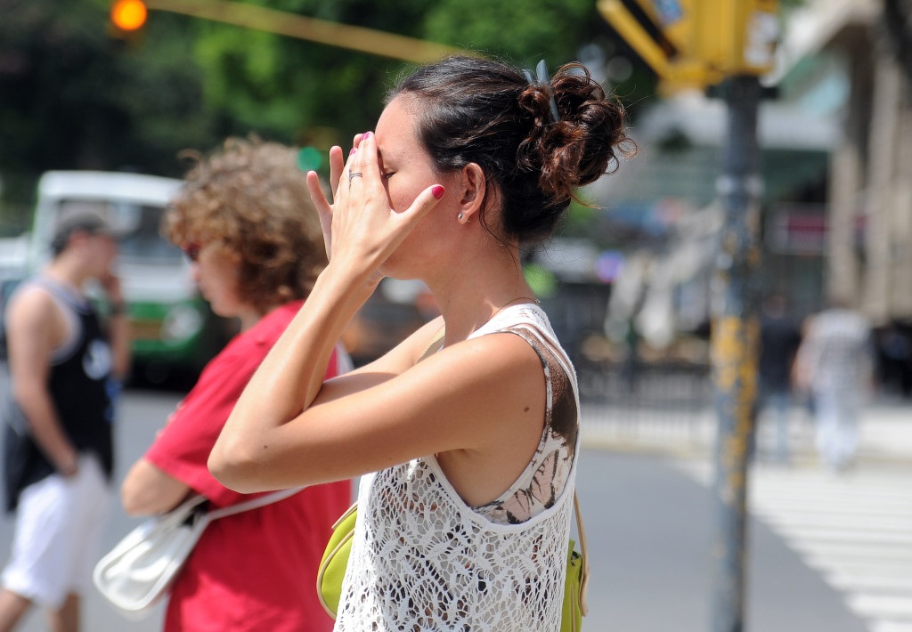 mujer tocándose la frente por el calor
