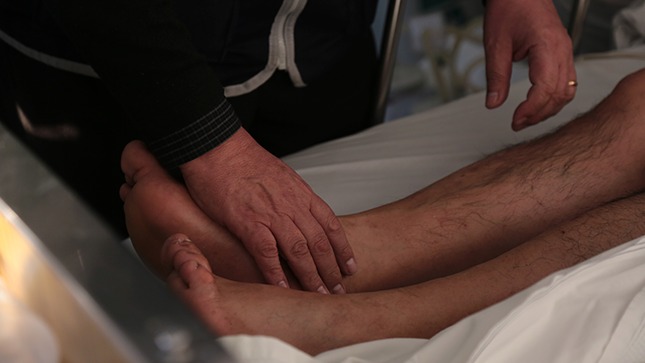 Se vwe al medico revisando las piernas adormecidas.