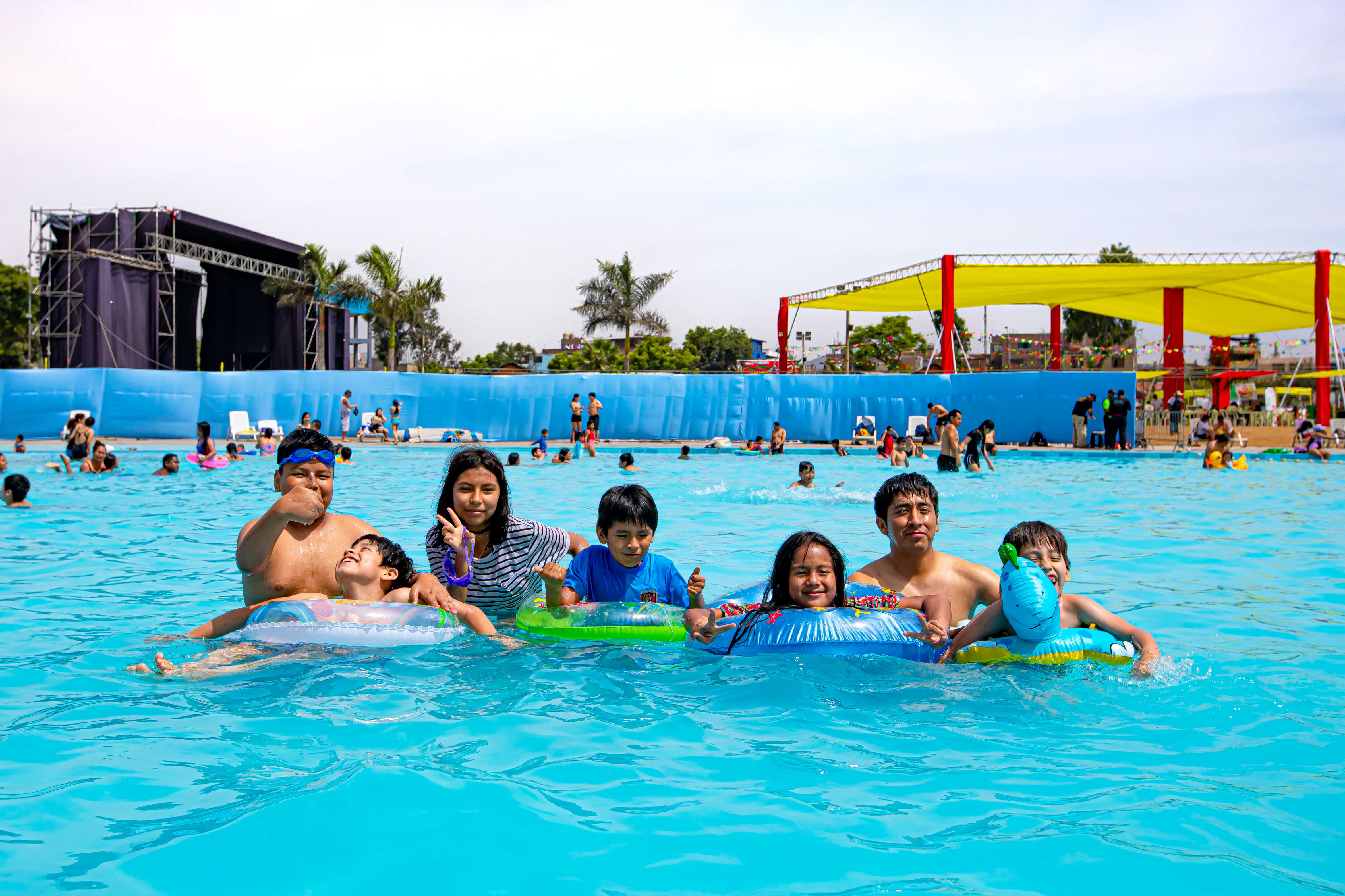 Niños disfrutando piscina con sus flotadores
