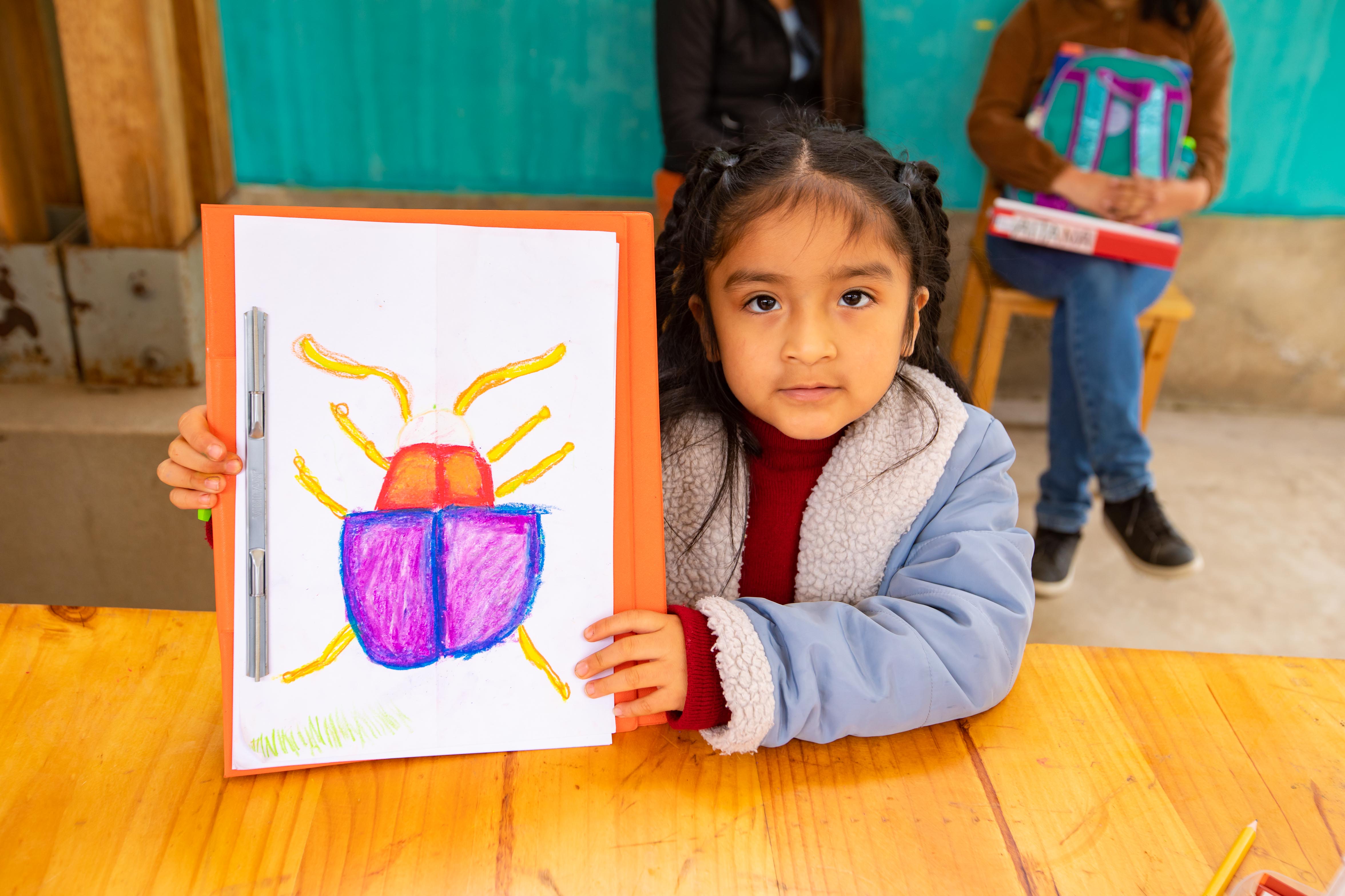 Niña mostrando su dibujo