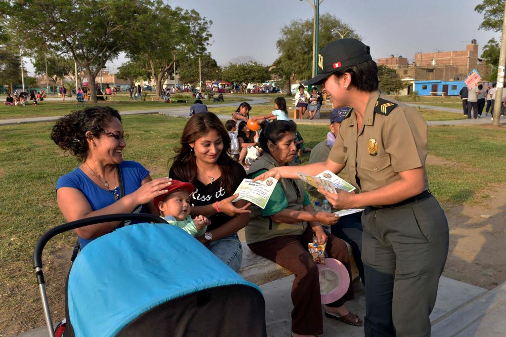 Mujer policía dialogando con vecinos