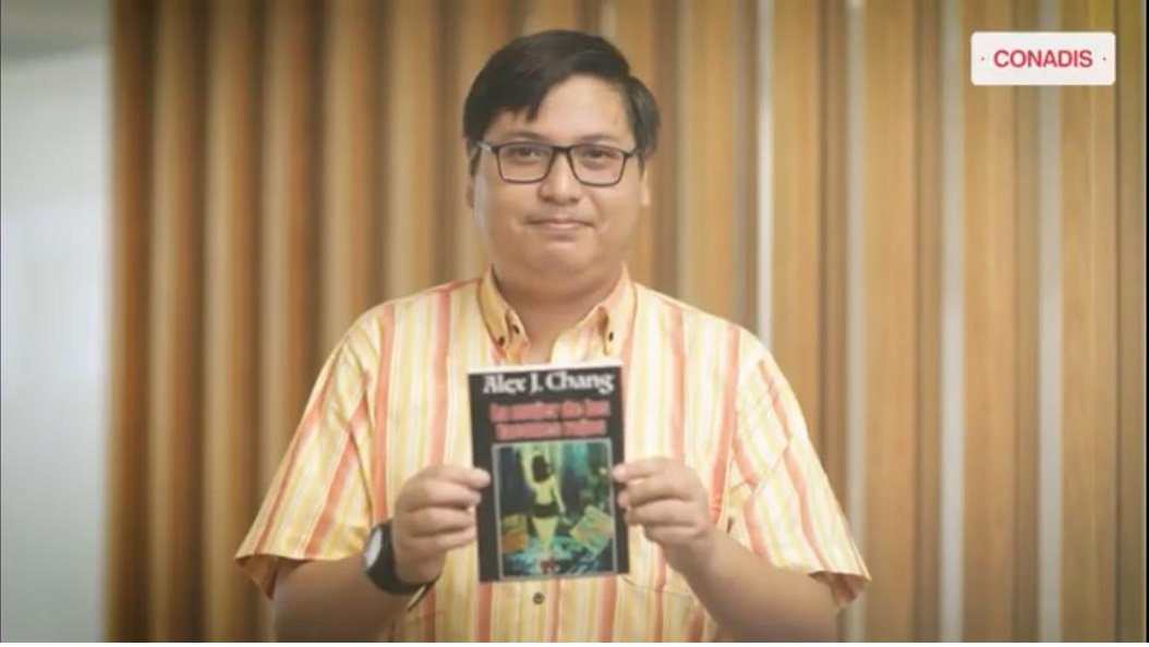 Imagen de Alex Chag un joven con autismo mostrando su libro que ha escrito esta en plano medio