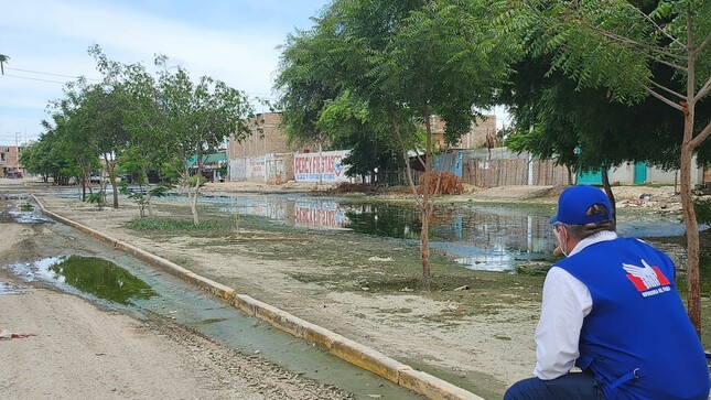 Representante de la Defensoría del Pueblo observando el agua de lluvia estancada