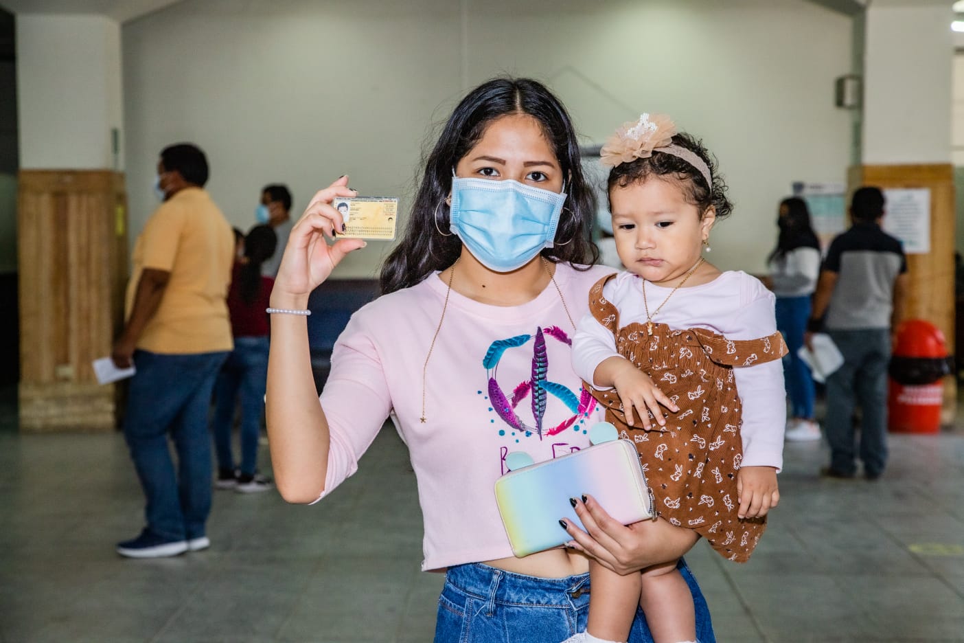 madre mostrando DNI con su bebé en brazos.