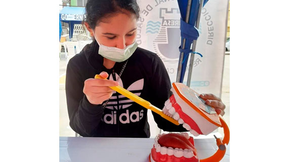 Niña, empleando la técnica del cepillado dental 