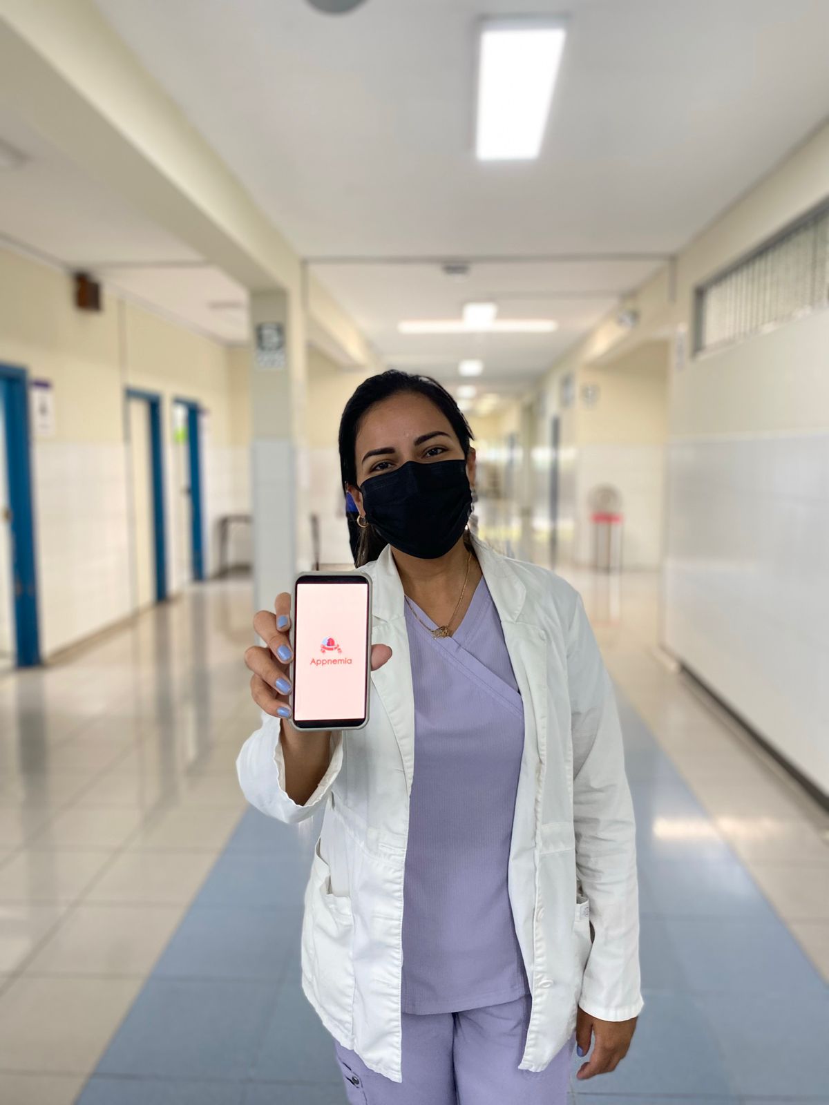 Personal médico mostrando el teléfono móvil con la aplicación activada