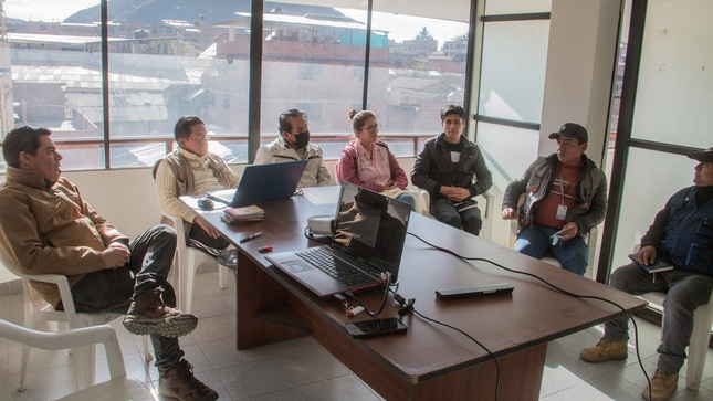 Servidores de la unidad ejecutora y otras instituciones sosteniendo una mesa de trabajo