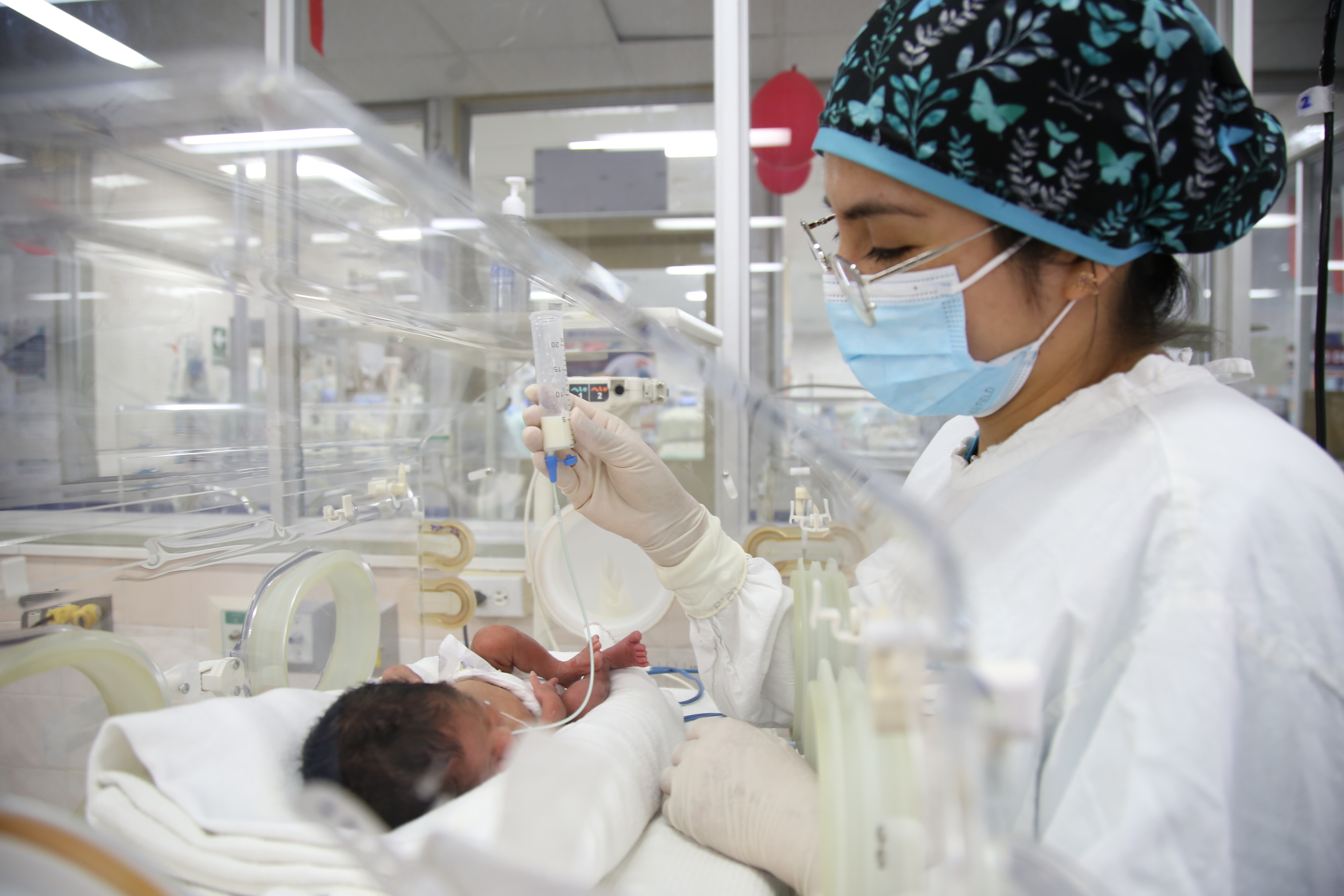 Enfermera alimenta con leche de banco a un bebé prematuro hospitalizado