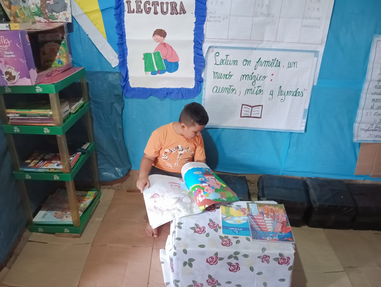 Niño disfrutando del espacio y leyendo un cuento en una de las casas de lectura.