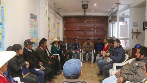 Servidores de la unidad ejecutora sosteniendo una mesa de trabajo con autoriades de  las zonas adyacentes a los sitios arqueológicos. 