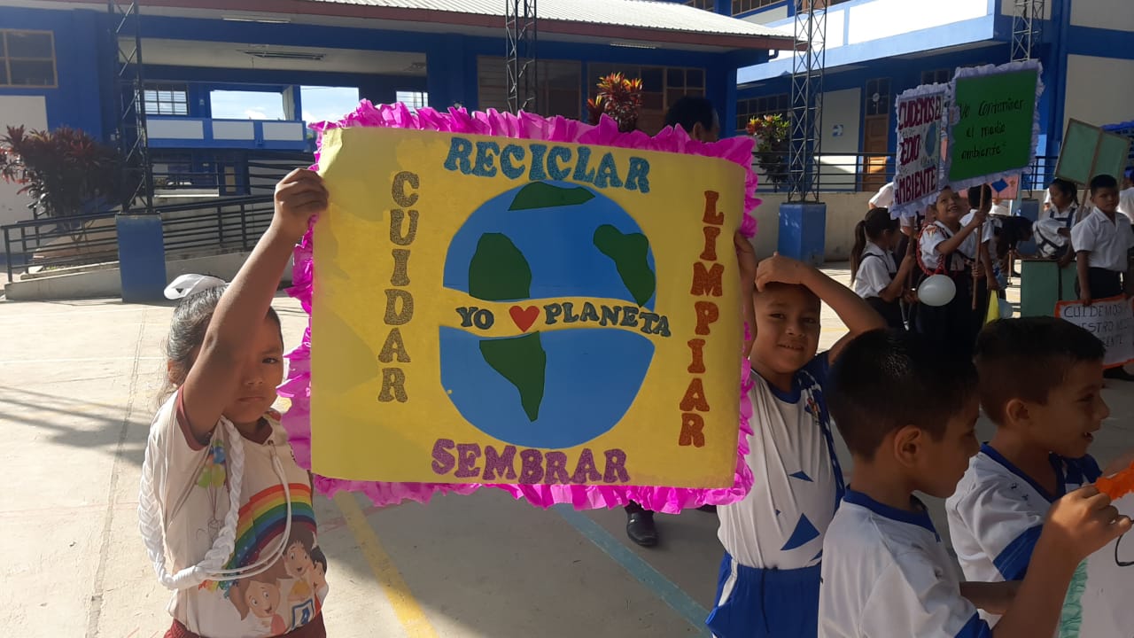 Niños muestran su pancarta sobre el día del medio ambiente.