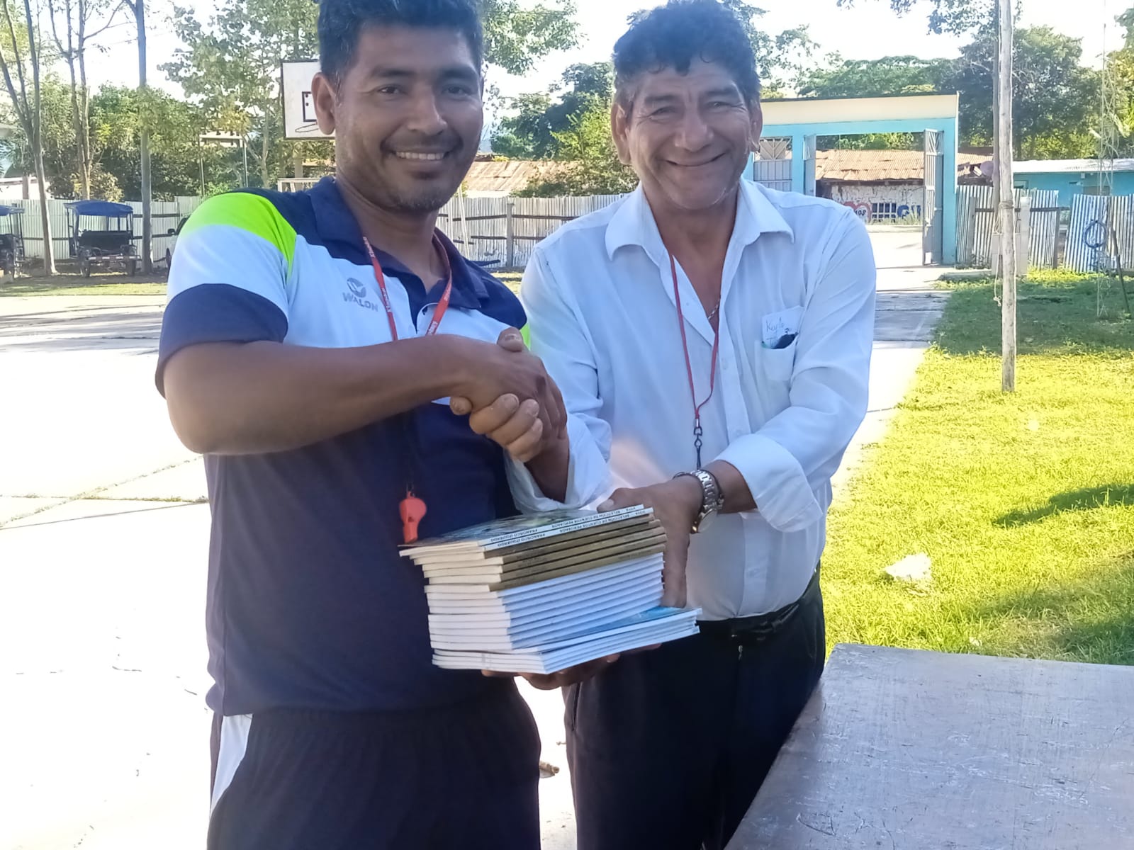Autor de libros entregando algunos ejemplares a docente de I.E. beneficiada.