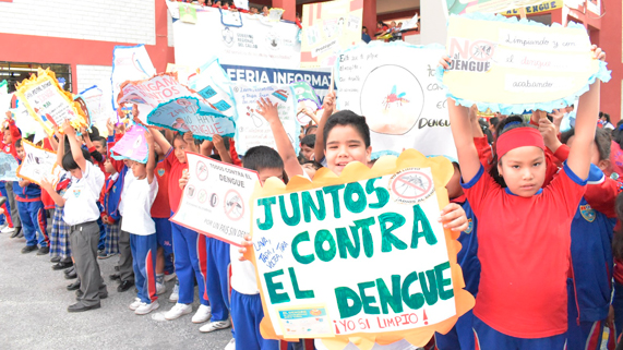 Población escolar portando afiches alusivos a medidas contra el dengue.